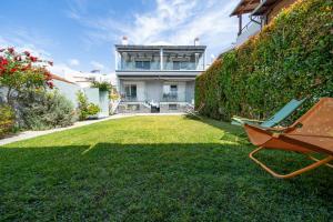 a yard with a bench and a house at Edem Luxury Apartments in Nea Peramos
