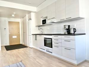 Una cocina con gabinetes blancos y encimera. en Tammer Huoneistot - City Suite 5 - Own Sauna, Air conditioning, Balcony & Best Location, en Tampere 7 fotos más