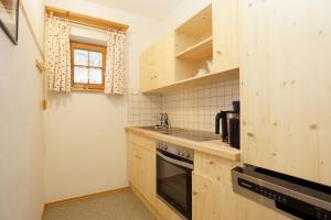 a kitchen with wooden cabinets and a sink and a stove at Feriengut zum Fürst´n in Eppenschlag