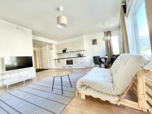 uma sala de estar com um sofá e uma mesa em Tammer Huoneistot - City Suite 5 - Own Sauna, Balcony & Best Location em Tampere