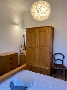 a bedroom with a bed and a cabinet and a guitar at 4B Millhill Street in Dunfermline