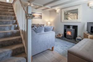 a living room with a staircase and a fireplace at Dollars Cottage - 4 Bedroom Cottage - Llangennith in Llangennith