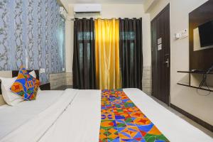 a bedroom with a bed with a colorful comforter at FabHotel Royal Stay Inn in Allahābād