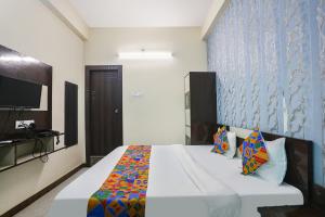 1 dormitorio con 1 cama grande y TV en FabHotel Royal Stay Inn, en Allahābād