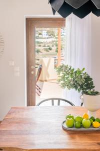 Syra Suites في Vári: طاولة خشبية عليها صحن فاكهة