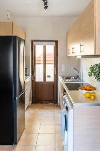 una cucina con frigorifero nero e lavandino di Syra Suites a Vári Altre 37 foto