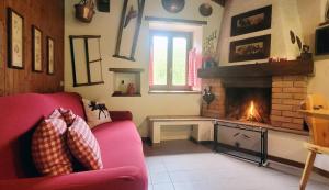 sala de estar con sofá rojo y chimenea en Charming Mountain Hut on Grigna Mountain - Como Lake, en Pasturo