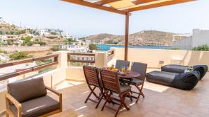 een patio met een tafel en stoelen op een balkon bij Syra Suites in Vári