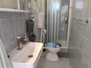 ein Badezimmer mit Toilette, Waschbecken und Dusche in der Unterkunft Villa Grande Vista - Lovely Apartment with Private spacious lush mediterranean patio and Sea view in Trogir + 37 Fotos