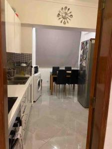una cucina con tavolo, sedie e frigorifero di An elegant & cozy apartment ad Amadora Altre 11 foto