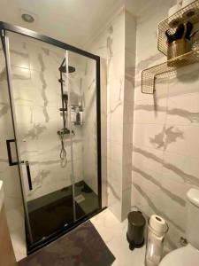 bagno con doccia e porta in vetro di An elegant & cozy apartment ad Amadora