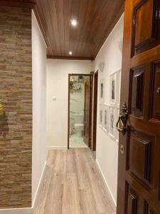 un pasillo con una puerta que conduce a un baño en An elegant & cozy apartment en Amadora