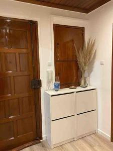 a room with a door and a dresser with a plant on it at An elegant & cozy apartment in Amadora