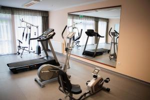 un gimnasio con varias bicicletas estáticas y un espejo en Arkánum Hotel, en Balatonmáriafürdő