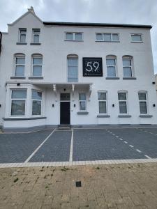 a white building with a sign on the front of it at Accommodation Fifty-Nine in Blackpool