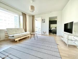uma sala de estar com um sofá e uma televisão de ecrã plano em Tammer Huoneistot - City Suite 5 - Own Sauna, Balcony & Best Location em Tampere