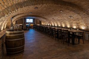 a wine cellar with a row of tables and chairs at Várkonyi Apartman in Gyula