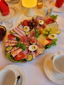 eine Platte mit Käse und Fleisch auf dem Tisch in der Unterkunft Pension Benedikt in Aschau am Inn