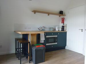 a kitchen with a counter and a table with a microwave at Tanleys - Skye Pod in Grantown on Spey