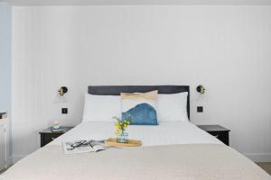sypialnia z dużym białym łóżkiem z dwoma stołami w obiekcie Mayflower, Maritime Suites w mieście Brixham