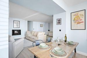a dining room and living room with a table and chairs at Mayflower, Maritime Suites in Brixham