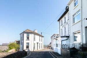 an empty street with two white buildings on the side at Mayflower, Maritime Suites in Brixham