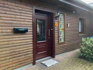 una casa de madera con una puerta roja. en Ferienwohnung Bädke en Müden