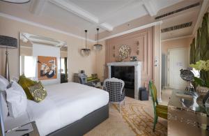 a bedroom with a white bed and a fireplace at Aria Hotel Budapest by Library Hotel Collection in Budapest