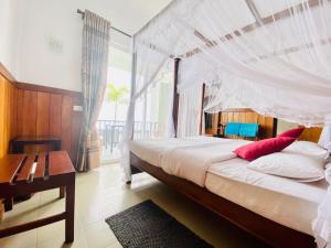 a bedroom with a large bed with a canopy at Srilak View Holiday Inn in Haputale