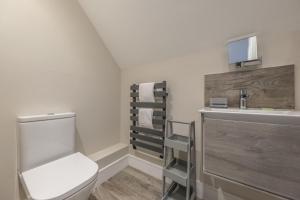 a bathroom with a white toilet and a sink at The Goosebec in Burnham Market +49 photos