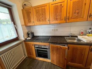 a kitchen with wooden cabinets and a sink and a stove at Schnitzer-Stüble in Missen-Wilhams +5 photos