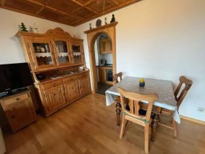 a dining room with a table and a kitchen at Schnitzer-Stüble in Missen-Wilhams
