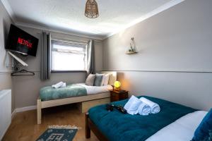 een kamer met 2 bedden en een tv. bij Charming 2-Bed Home in Neath in Skewen