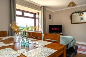 a dining room with a table and a television at Charming 2-Bed Home in Neath in Skewen