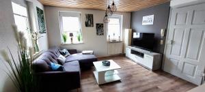 a living room with a couch and a tv at Gemütliche Ferienwohnung am Schwarzwaldrand in Jettingen