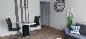 a living room with a table and chairs and a clock at Gemütliche Ferienwohnung am Schwarzwaldrand in Jettingen +14 photos