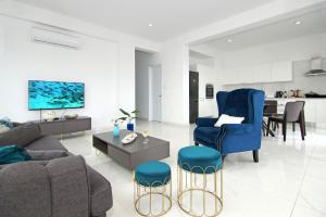 een woonkamer met een bank, stoelen en een tafel bij Villa Amity in Protaras