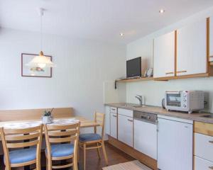 uma cozinha com uma mesa e cadeiras e um micro-ondas em Haus Gant em Sankt Gallenkirch