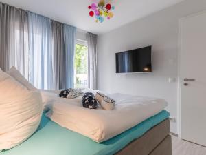 two people laying on a bed in a bedroom at Villa Baltic Zingst - AP Strandfein in Zingst