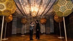 mężczyzna i kobieta stojący w pokoju ze światłami w obiekcie Ｎasu Utopia Minosawa Art Village w mieście Nasu