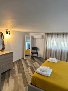 a bedroom with a yellow bed and a mirror at Sanduli Luxury House in Agrigento