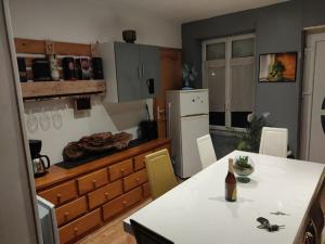 a kitchen with a table with a bottle of wine at Gîte campagne proche mer in Saint-Pierre-Brouck