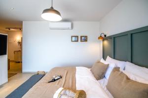 a bedroom with a large bed with a green headboard at Boutique El-Rom in El-Rom