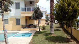 a apartment building with a swimming pool and palm trees at SunSet Apartments 4,5,6 in Belek