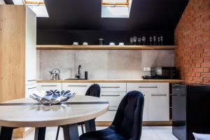 uma cozinha com uma mesa e cadeiras e uma parede de tijolos em Hostel Dzika Kaczka 