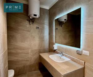 a bathroom with a sink and a mirror at Prime Holidays Seashell in El Alamein +67 photos