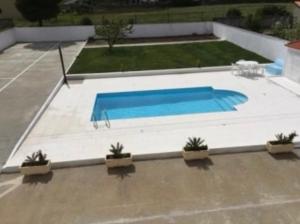 a swimming pool in a yard with potted plants at Residência Vitória de São Marcos in Trancoso