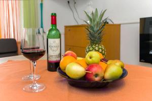 a bowl of fruit on a table with a glass of wine at Holiday House Lapis in Janjina