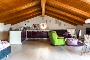 a kitchen and a living room with wooden ceilings at Residenza a schiera vista lago Feriolo in Feriolo