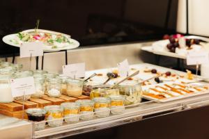 a buffet of food in jars and plates of food at Mamaison Le Regina Boutique Hotel in Warsaw